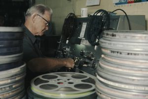Man working on old film reels