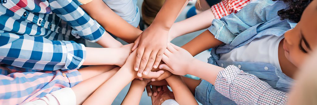 Hands clasped together in the center of a circle of people