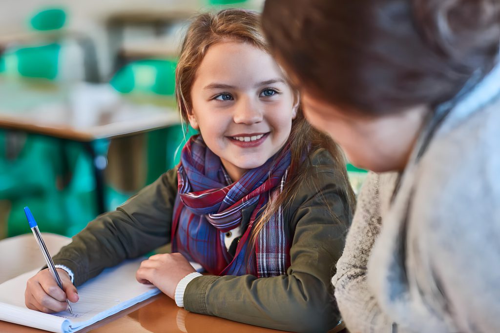 Student smiles up at an adult