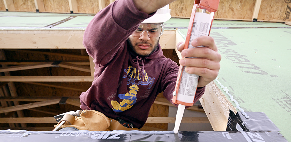 A male student works on a construction site.