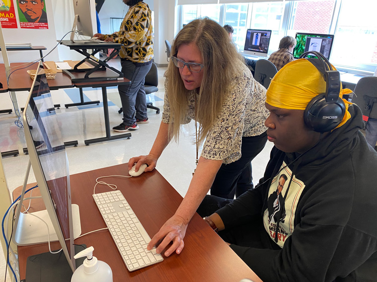 student and teacher working on computer