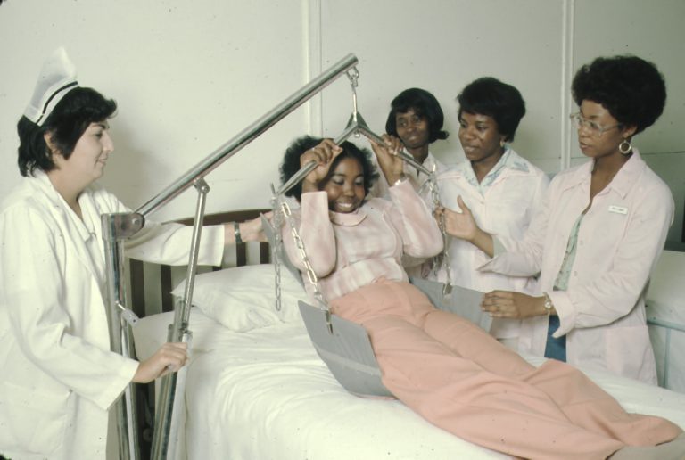 An Adult Education course with 4 women learning how to use a patient lifting device.