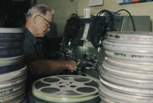 Man working on old film reels.