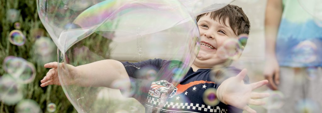 A young student delights in large bubbles.