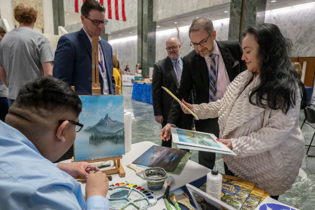 Commissioner of Education and her chief of staff stand with the Putnam Westchester BOCES district superintendent and one of his students admiring artwork at a the Putnam-Northern Westchester BOCES table